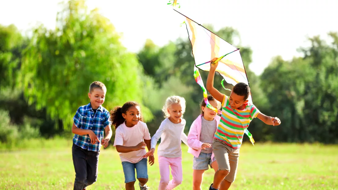 Group of happy children with kite in park